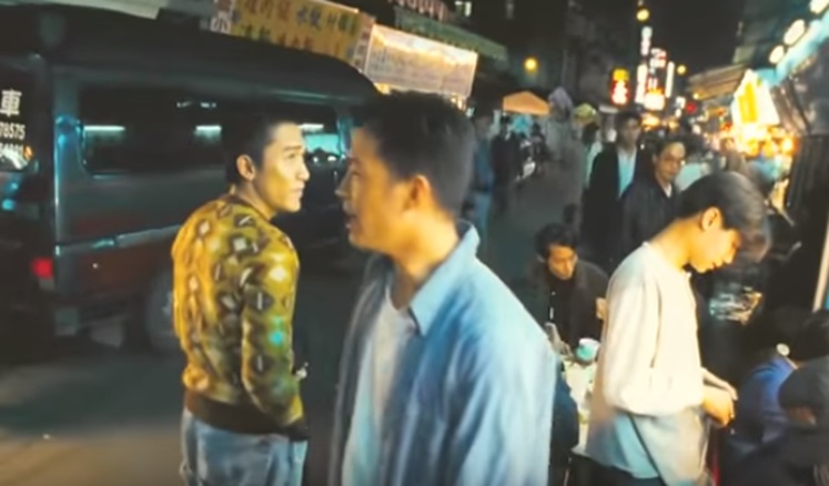 温潤的台北庶民風景裡,黎耀輝離開小張家的夜市攤位,仍微笑着駐足回望